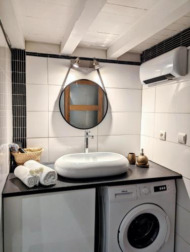 une salle de bain avec un lavabo et une machine à laver dans l'établissement L'escale secrète - Emplacement central premium, à Nîmes