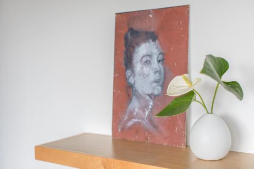 a painting of a man on a shelf next to a plant at Abpopa Hillcrest in San Diego