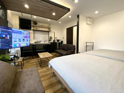 1 dormitorio con 1 cama y escritorio con cocina en Frontier 1st Building - Vacation STAY 15474, en Kagoshima