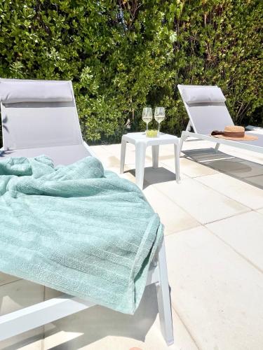 two white chairs sitting next to a table with a blanket at Casa dos Trevos, 5 Bedroom Villa with Pool in Lagos