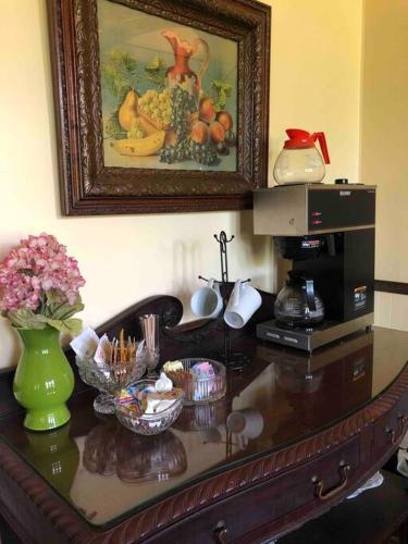 een tafel met een schilderij aan de muur en bloemen erop bij The Vine Bed & Breakfast, LLC in Dundee