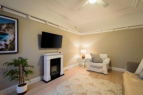 sala de estar con chimenea y TV de pantalla plana en Best location in Manly Harbour view, en Sídney