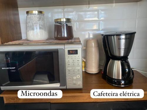 a kitchen counter with a microwave and a blender at Casa de praia com vista para o mar in São Sebastião