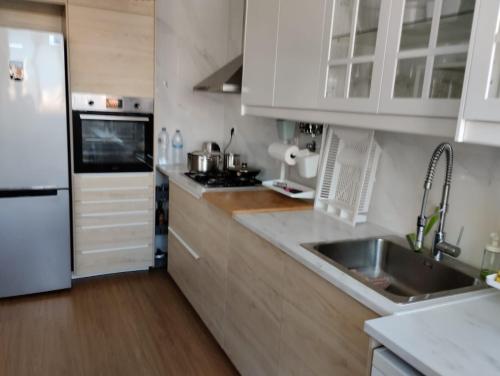 a kitchen with white cabinets and a stainless steel sink at Lisbon West Space in Lisbon