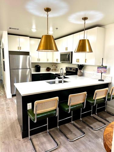 a kitchen with a counter with chairs and a sink at The Vault - Perfect Location! in Oxford