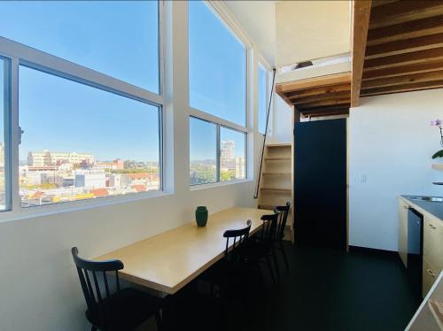 a dining room with a table and chairs and large windows at Abpopa Hillcrest in San Diego