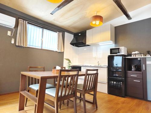 a kitchen with a table and chairs in a room at 清潔#快適#広々なんば駅徒歩8分#9名宿泊可#Wi-Fiswitch#大画面TV in Osaka