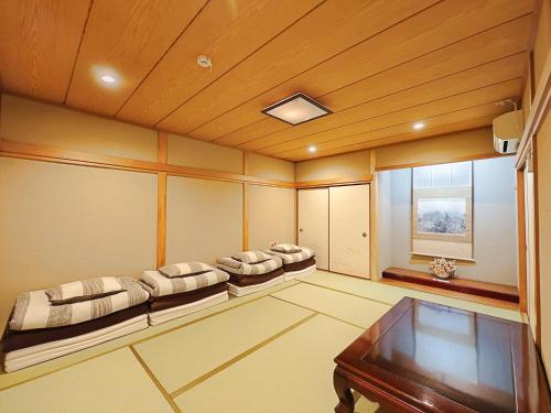 a room with three beds and a table in it at 清潔#快適#広々なんば駅徒歩8分#9名宿泊可#Wi-Fiswitch#大画面TV in Osaka