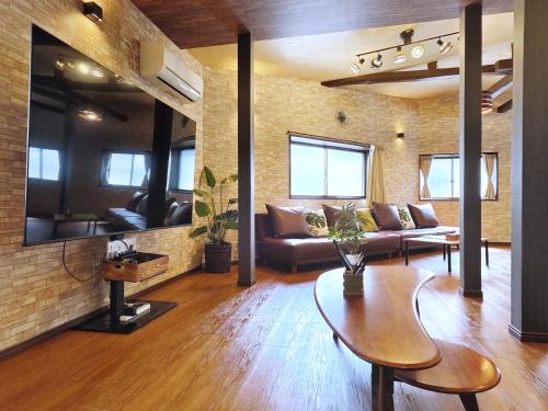 a living room with a couch and a table at 清潔#快適#広々なんば駅徒歩8分#9名宿泊可#Wi-Fiswitch#大画面TV in Osaka
