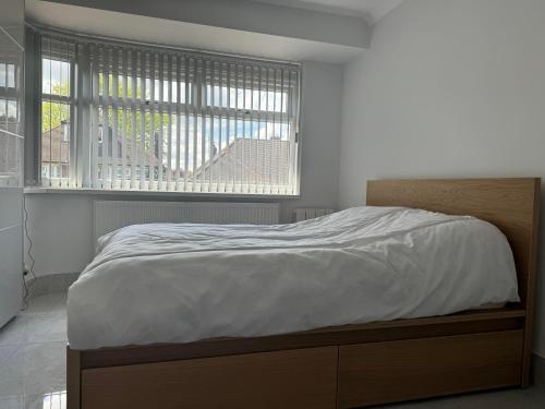 a bed in a bedroom with a large window at Instant Home in Luton