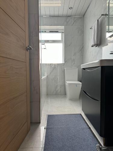 a bathroom with a sink and a toilet and a window at Instant Home in Luton
