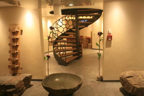 a room with a staircase and a bench and a table at Logis Gourmet & Relax Hotel De La Sure in Esch-sur-Sûre