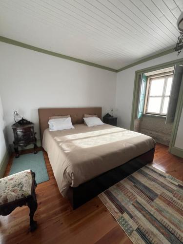 um quarto com uma cama grande e uma janela em Casa do Compasso em Farminhão