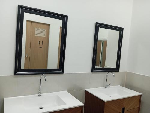 een badkamer met 2 wastafels en 2 spiegels bij Hotel The Journey Patong New in Patong Beach