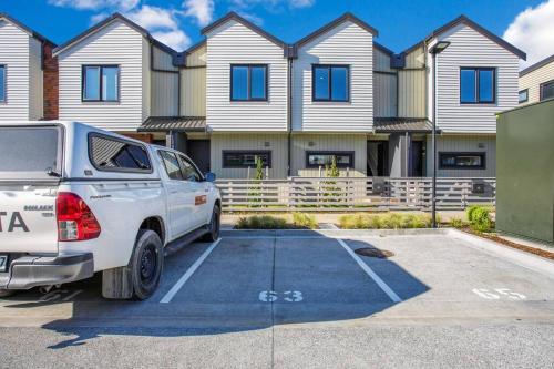 a car parked in a parking lot in front of a house at Modern Family Home 7km Airport Free Park in Auckland