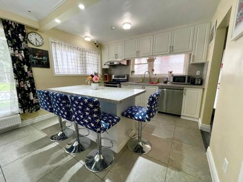 a kitchen with a counter and blue chairs in it at Bright&Modern Space Perfect for couple and Family Step to public transit in Toronto in Toronto