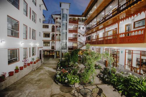 un edificio de apartamentos con plantas en el patio en Quechua Hotel Cusco, en Cusco