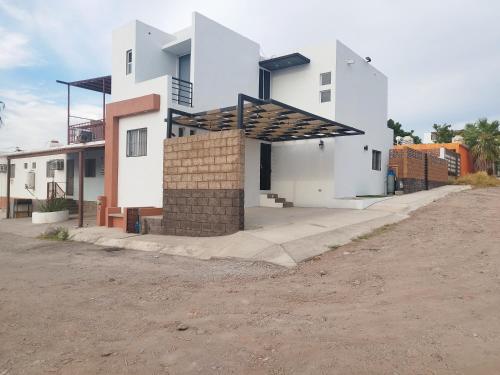 a white house with a roof on a dirt road at Casa Cosmos 'Alberca Privada' in San Carlos
