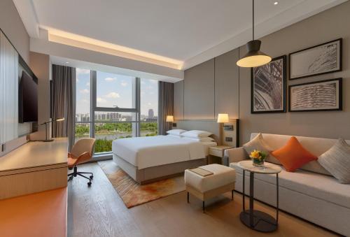 a hotel room with a bed and a couch at Hyatt Place Nantong Xinghu City Plaza in Nantong