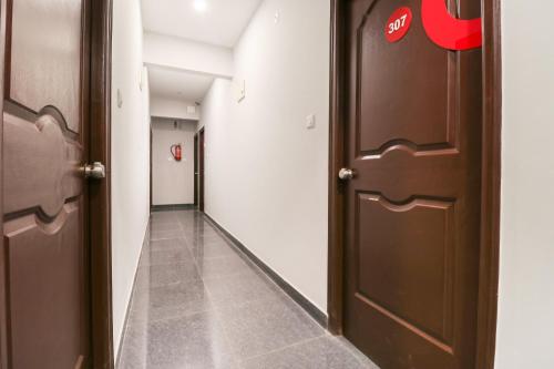 a hallway with two brown doors and a hallwayngth at Hotel O IRA Sathyajyothi Comfort in Bengaluru