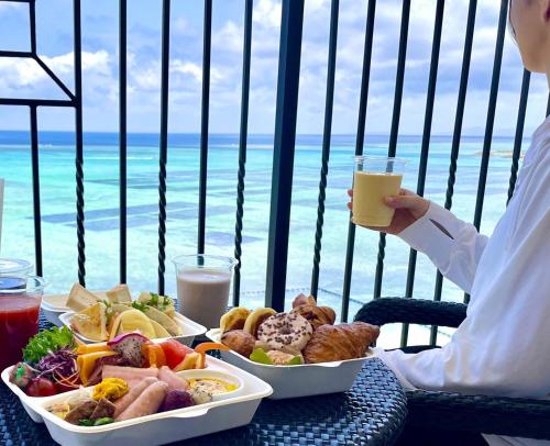 a person sitting at a table with a tray of food at Hotel Monterey Okinawa Spa & Resort in Onna