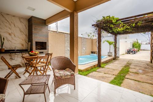 普里亞的住宿－Casa no PREÁ COM PISCINA !，一个带桌椅的庭院和一个游泳池