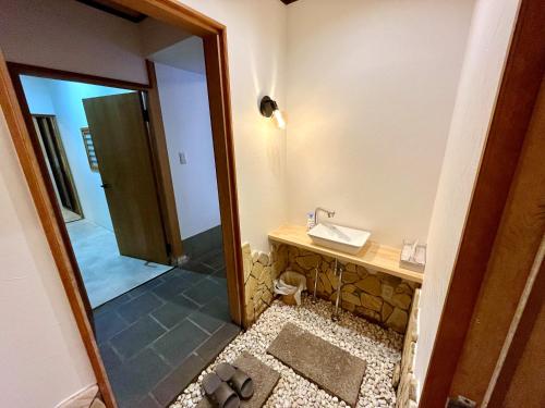 a bathroom with a sink and a mirror at 尾道stay源 -MINAMOTO- in Kaneyoshi
