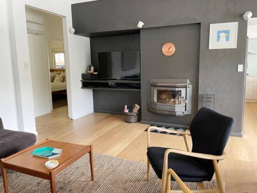 a living room with a couch and a fireplace at NINE at Berowra Waters, luxury waterfront with hot tub in Berrilee