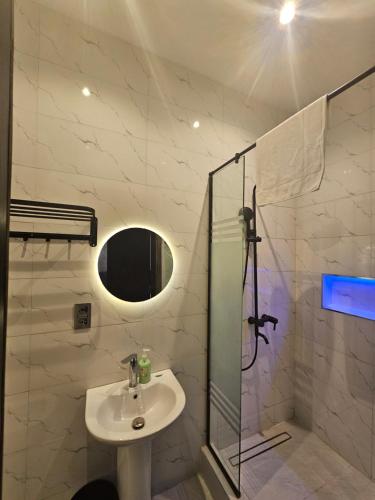 a bathroom with a sink and a glass shower at Sapphire Residences by Crystal Magodo in Ikeja