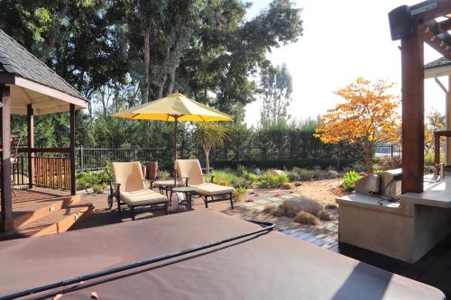 a patio with a table and chairs and an umbrella at The Sanctuary in Laguna Hills