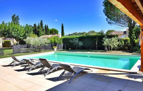 a swimming pool with chairs and a house at La Villa Du Colombier in Barbentane