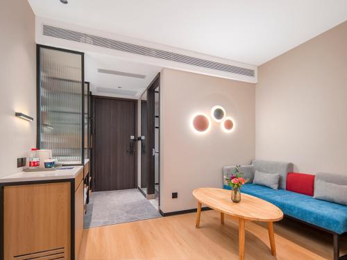 a living room with a blue couch and a table at Campanile Beijing Tongzhou Universal Resort Linheli in Tongzhou