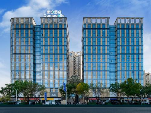 two tall buildings with blue windows in a city at Campanile Beijing Tongzhou Universal Resort Linheli in Tongzhou