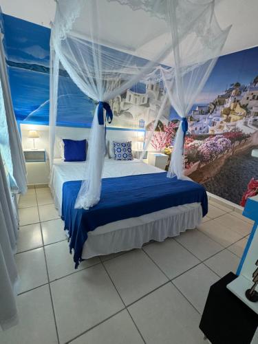 a bedroom with a bed with blue and white curtains at Flats Bela Vista Grécia in Macaé