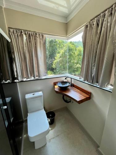 a small bathroom with a toilet and a window at Hotel Sítio Novo in Piratuba