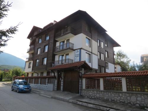 a blue car parked in front of a building at Apartments & Studios Mountain Romance in Bansko