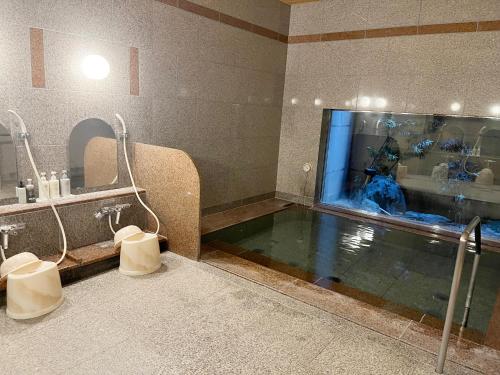 a bathroom with a large pool of water in a shower at Hotel Route-Inn Sapporo Ekimae Kitaguchi in Sapporo