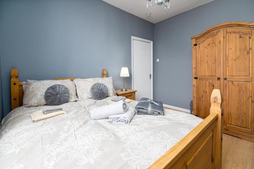 a bedroom with a large bed with blue walls at Fantastic House New Refurbished in London