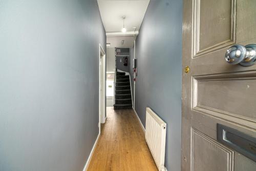 a hallway with a door and a wooden floor at Fantastic House New Refurbished in London
