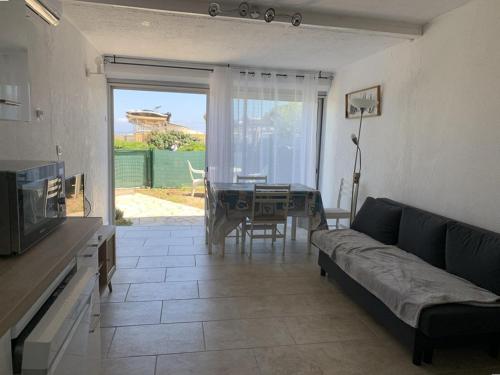 un salon avec un canapé et une table dans l'établissement T2 Hyères : à 50m de la Plage, Proche du Port, Jardinet Privatif, Idéal Familles - FR-1-335-202, à Hyères