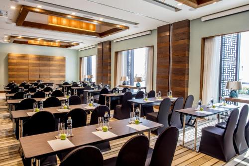 a large room with tables and chairs and windows at InterContinental Fujairah Resort by IHG in Al Aqah