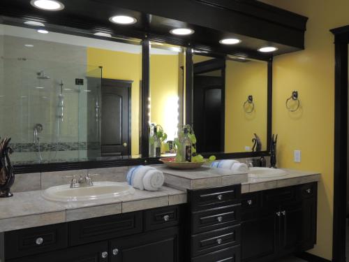 La salle de bains est pourvue de 2 lavabos et d'un grand miroir. dans l'établissement Summer Express Kelowna B&B - Villa Bellissimo Fran-Talia, à Kelowna