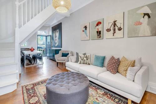 a living room with a white couch and a table at Ideal Location 3 bdr Paddo Terrace Parking & Pets in Sydney