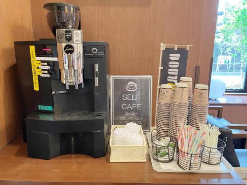 a table with a coffee maker and a set of cups at Hotel Route-Inn Fujieda-Eki Kita in Fujieda