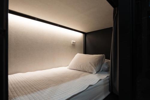 a bedroom with a bed with a light on it at Elephant in Busan