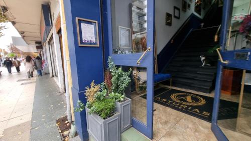 a blue building with potted plants next to a staircase at Hotel Asturias in Viña del Mar