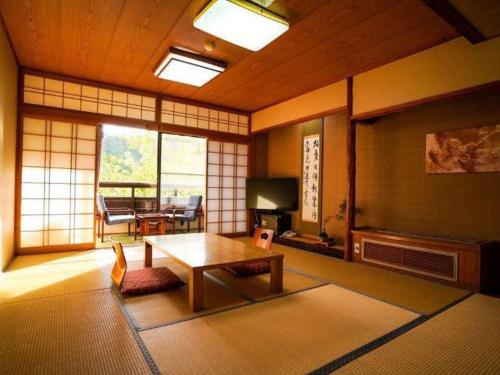 een woonkamer met een tafel en een woonkamer met een tafel bij Wafu Ryokan Misato in Minamioguni
