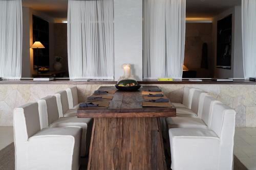 a dining room table with white chairs and a candle on it at Dali Shuanglang Anqi'erhai Resort Hotel in Dali Shuanglang