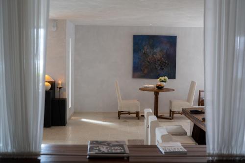 a living room with a table and chairs and a painting at Dali Shuanglang Anqi'erhai Resort Hotel in Dali Shuanglang
