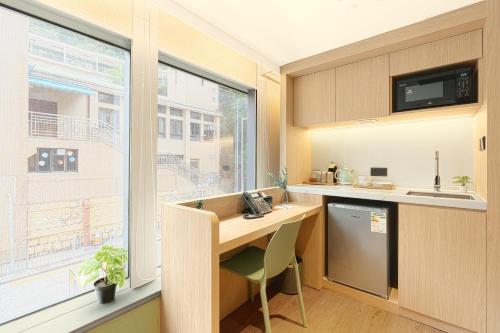 a small kitchen with a desk and a window at Urbanwood Ap Lei Chau in Hong Kong